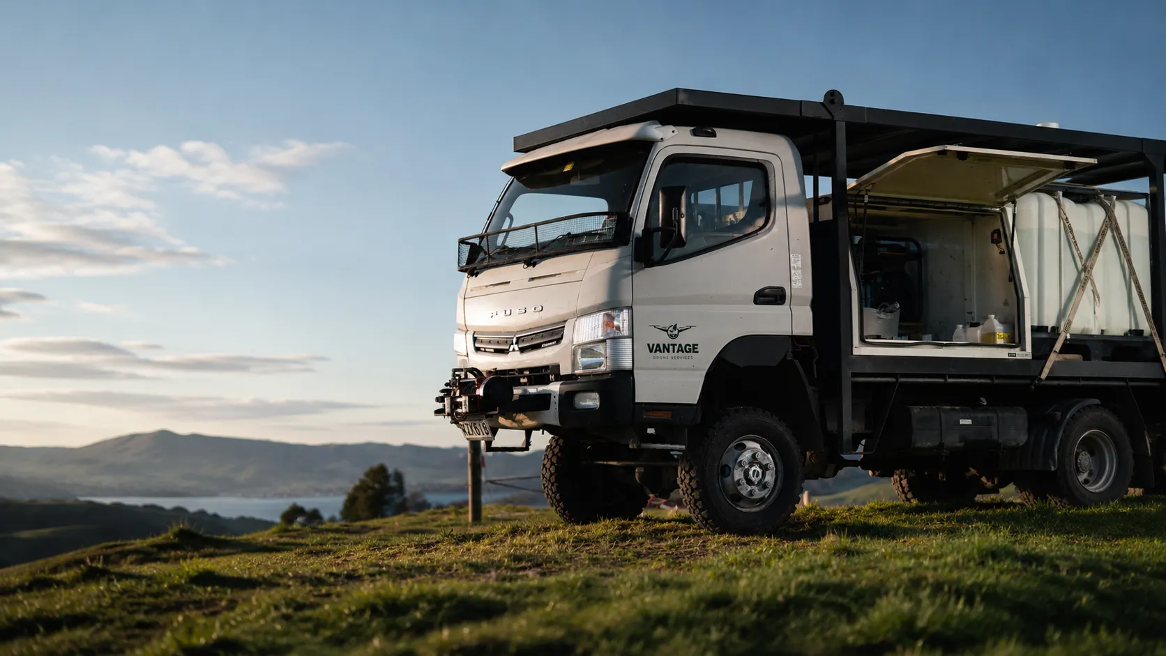 The branded Vantage Drone Services 4x4 service truck parked on a Bay of Plenty hilltop overlooking the region